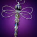Purple-themed handmade dragonfly ornament photographed on a solid background